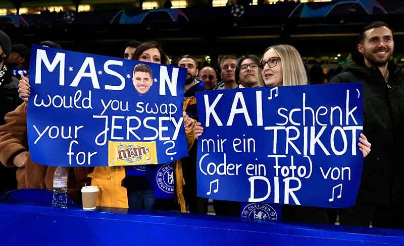 Chelsea fans vragen middels een kartonnen bord om de shirts van Mason Mount en Kai Havertz
